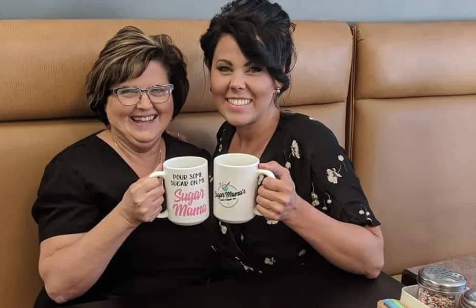 krysten and her mom, joanne touching coffee cups and embracing